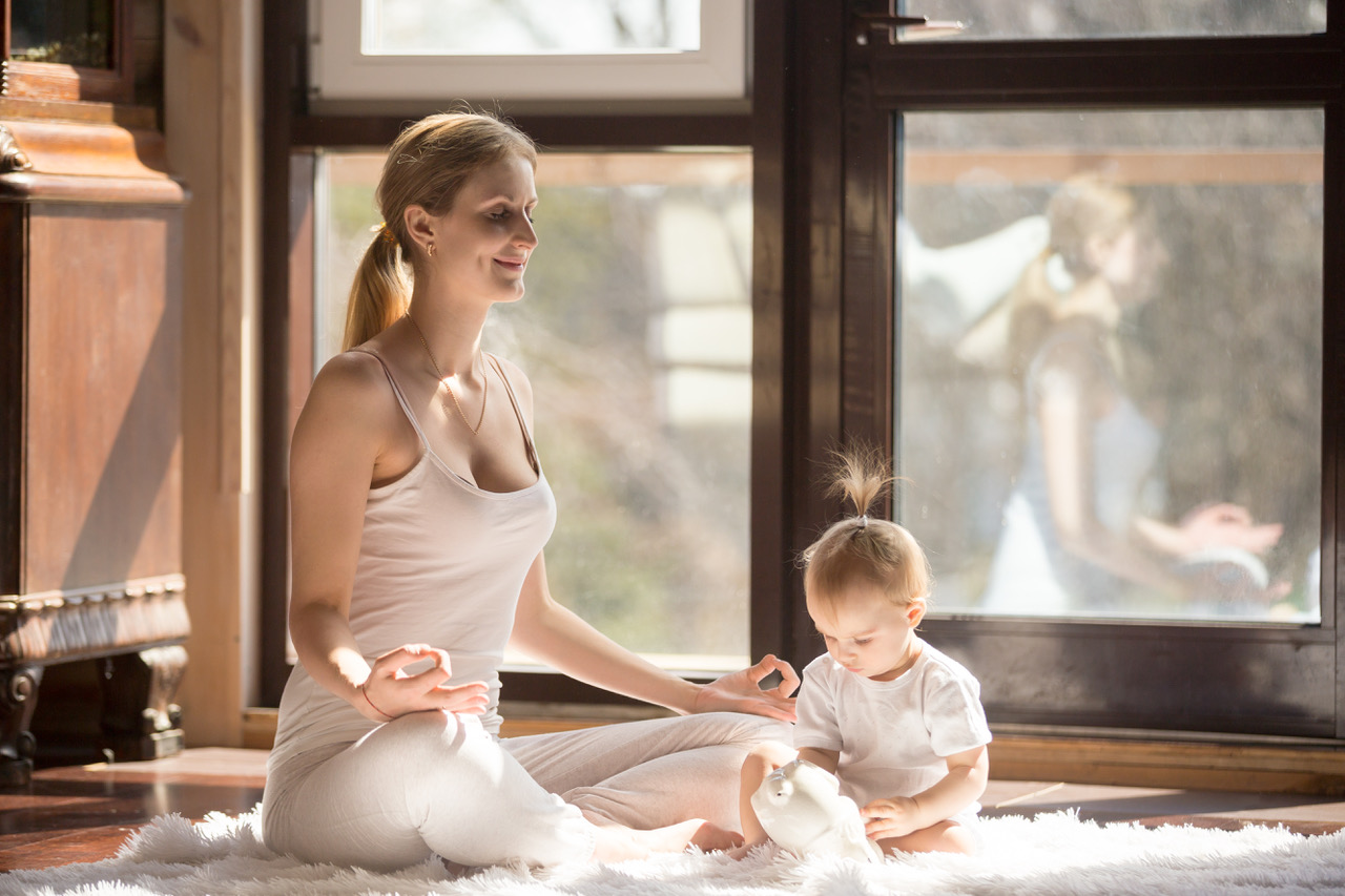 mom meditating next to baby