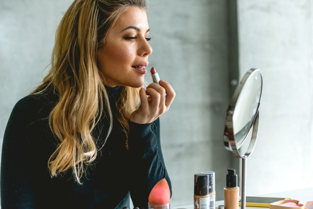 mom putting on lipstick